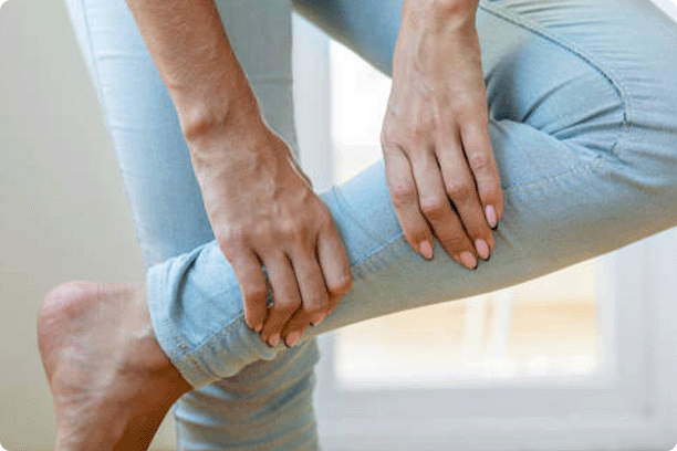 woman holding her calf, displaying pain in calf muscle of the woman