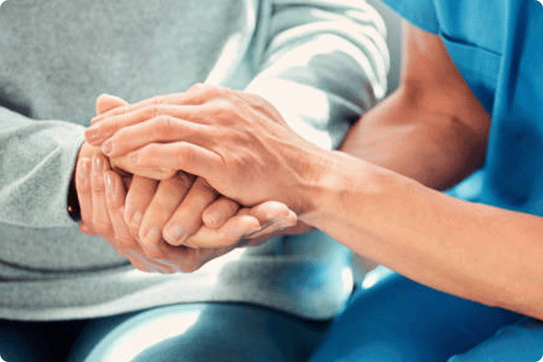 Closeup of nurse's hands holding an older patient's hands